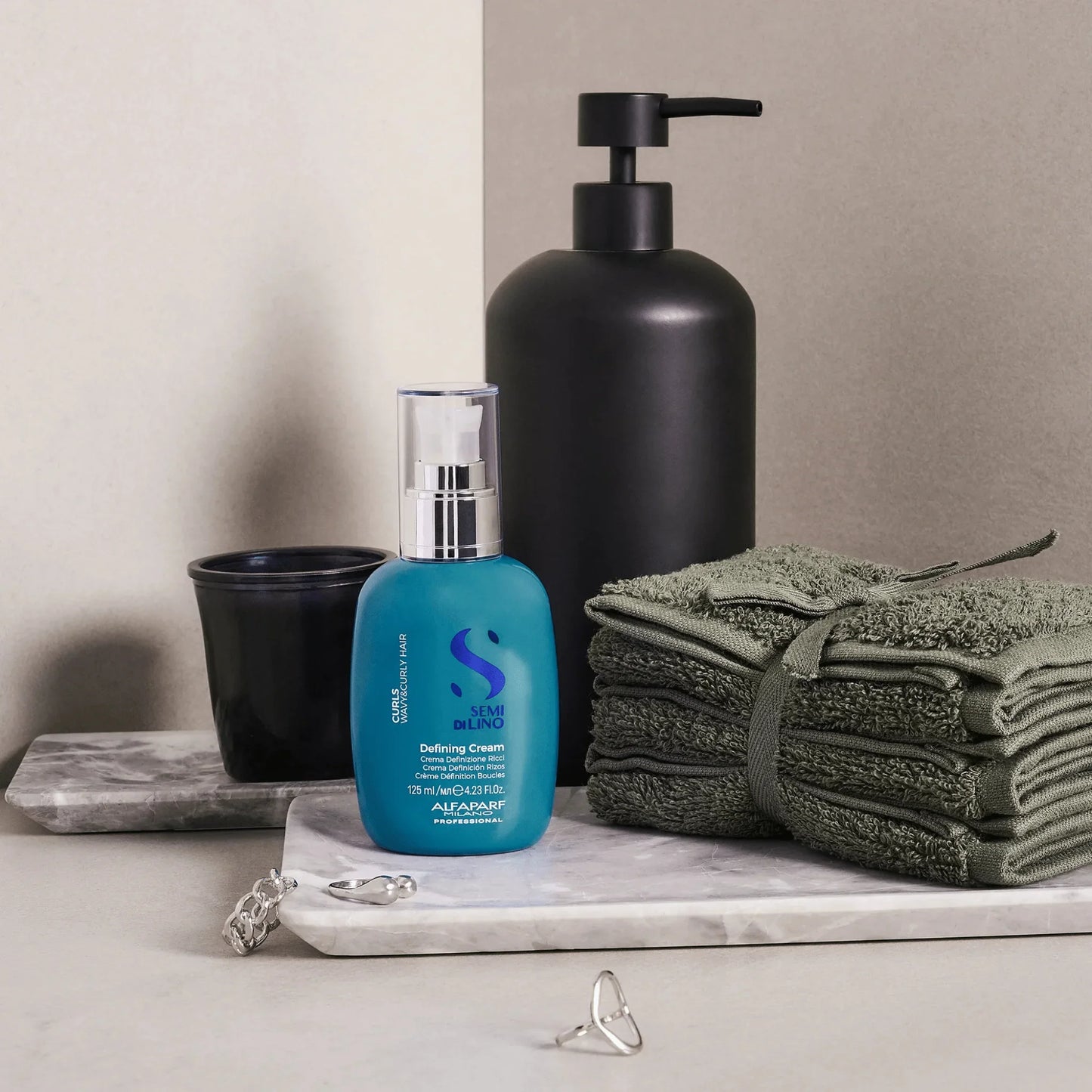 Alfaparf Semi di Lino Curls Defining Cream 125ml on marble tray with towels and pump bottle
