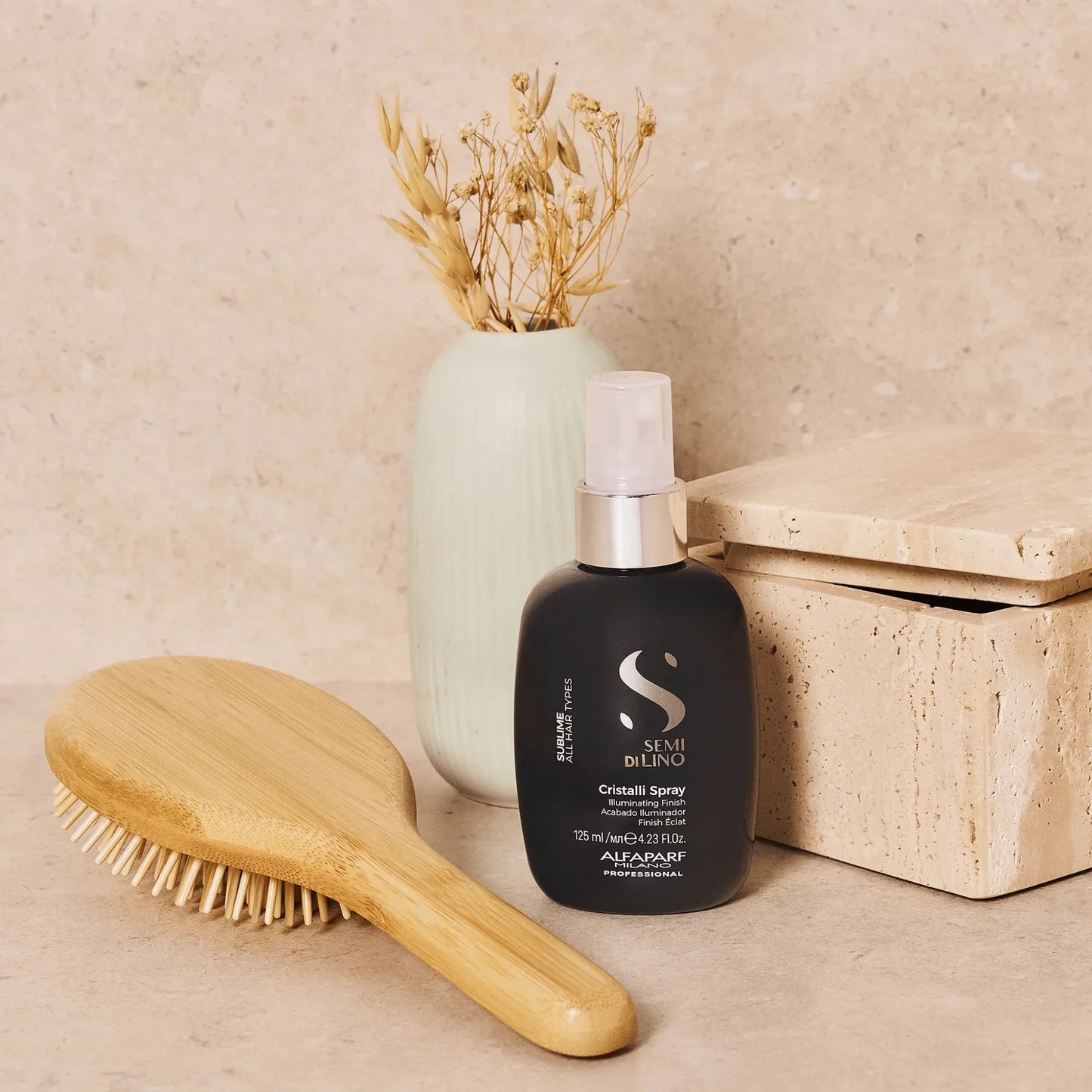 Semi Di Lino hair spray bottle with wooden brush and vase on neutral bathroom counter
