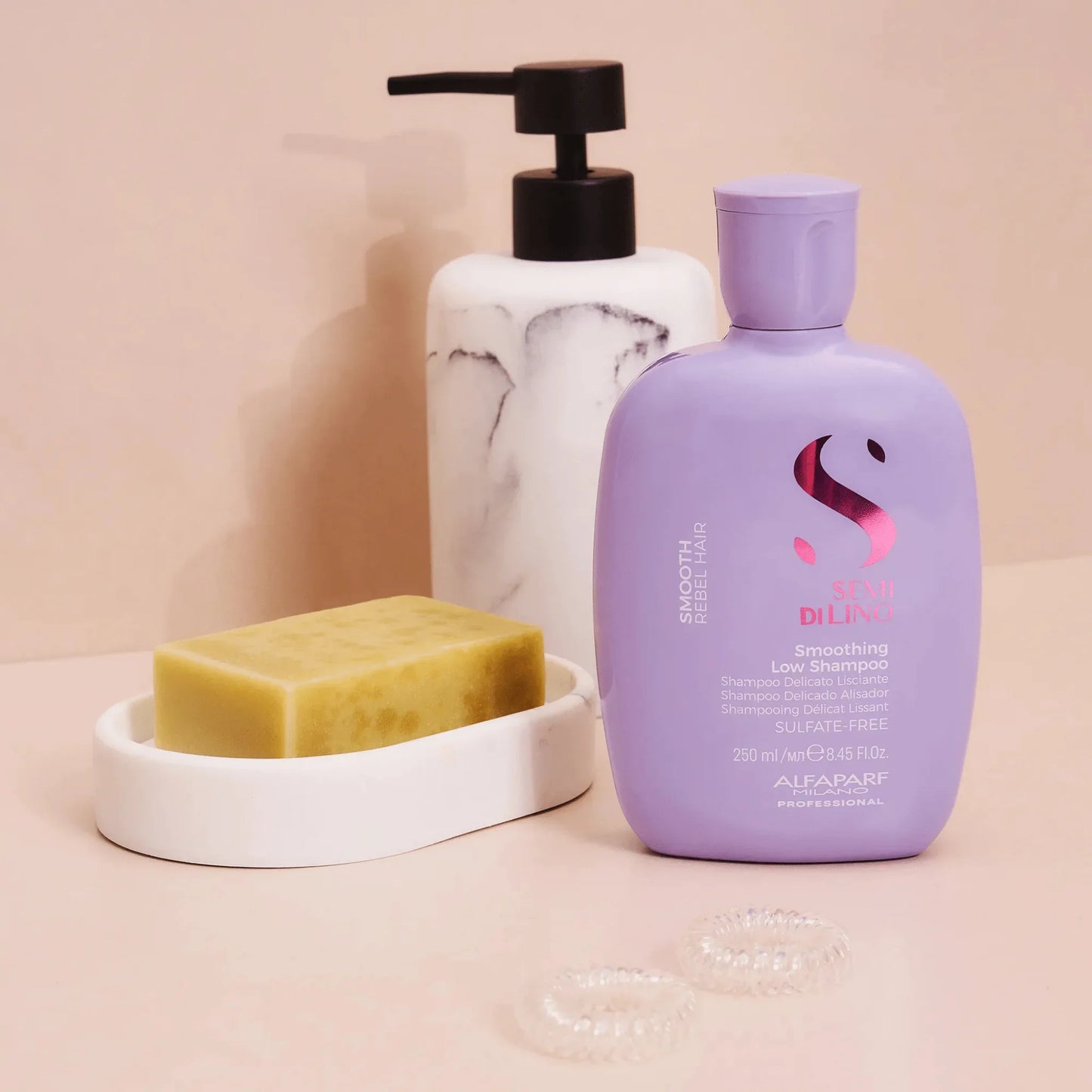 Purple Alfaparf Smoothing Low Shampoo bottle with marble pump, soap bar, and hair ties