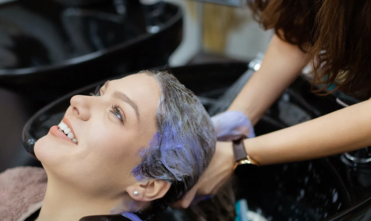 Woman enjoying professional hair wash at salon shampoo basin